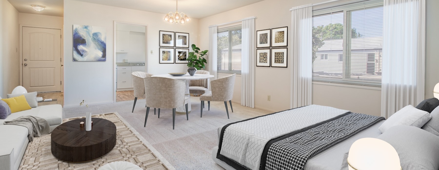 a studio with a bed, couch, table and chairs