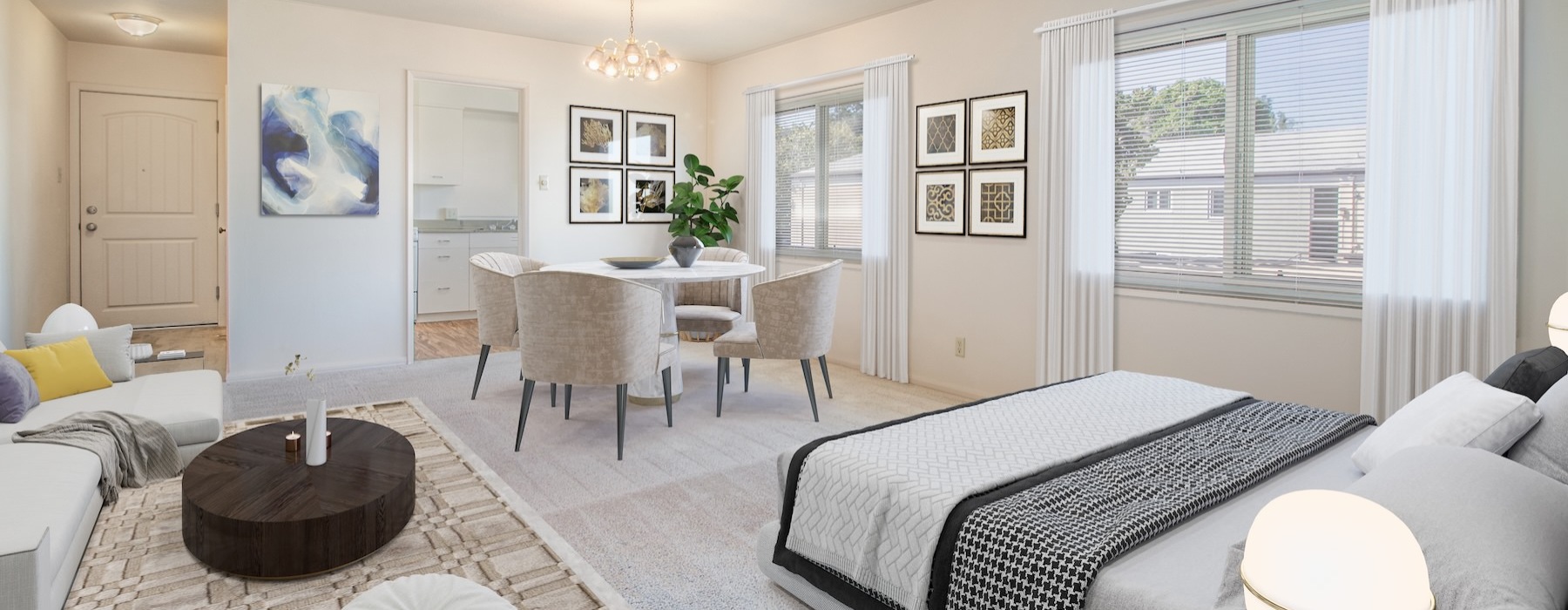 a studio with a bed, couch, table and chairs