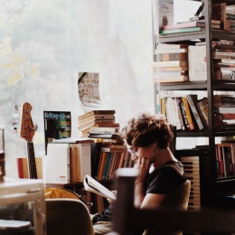 a woman in a bookstore with books and guitars